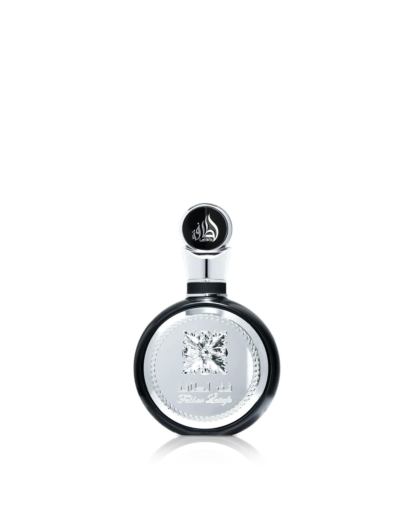 A close-up product shot of the Lattafa "Fakhar Lattafa" perfume bottle, which is round and black with a large, ornate central silver panel and an abstract diamond emblem, isolated against a white background.