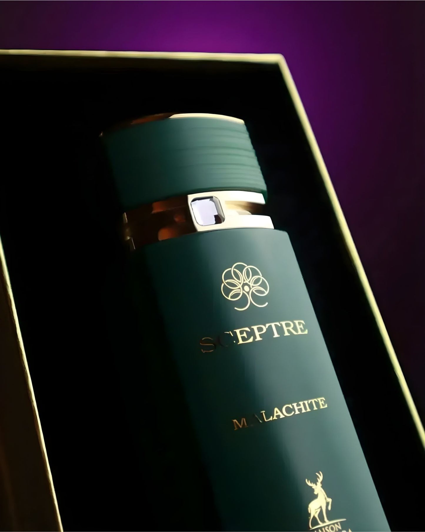 Close-up of the Maison Alhambra Scepter Malachite edp perfume bottle resting in a premium gold-lined display box with a moody purple background.
