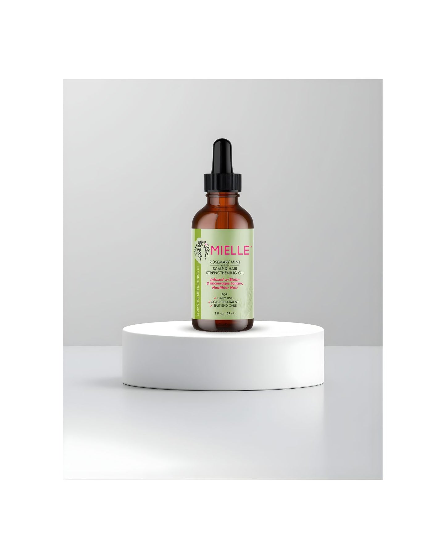 Mielle Rosemary Mint Scalp and Hair Strengthening Oil dropper bottle displayed on a white product stand.
