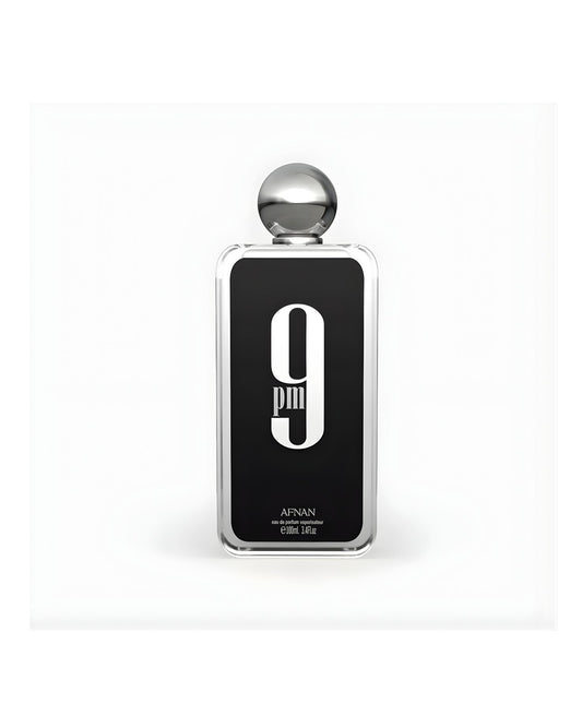 A rectangular glass bottle of Afnan 9 PM Eau de Parfum, 100ml / 3.4 fl.oz., featuring a black label with a large white "9 PM" graphic and a silver spherical cap, set against a white background.