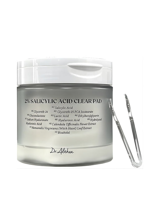 Dr. Althea 2% Salicylic Acid Clear Pad container with a list of key ingredients and a pair of silver plastic tongs resting against the jar.