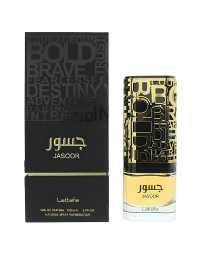 The Lattafa Jasoor Eau de Parfum bottle and its black and gold box. The box has large, stylized words like 'BOLD' and 'BRAVE' on the top section, and the bottle has a matching cap with similar word cutouts over a gold interior.