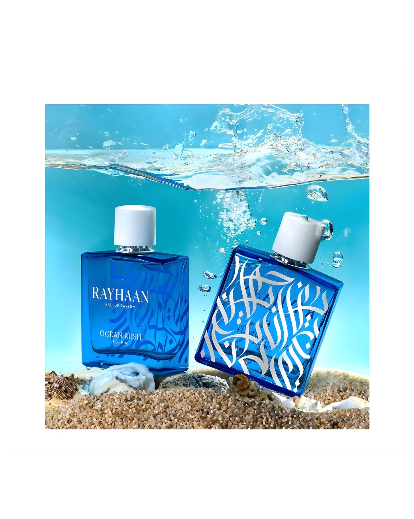 Two bottles of Rayhaan Ocean Rush Eau de Parfum for Men partially submerged in blue water with splashing, resting on wet sand and seashells. This fresh, aquatic fragrance is perfect for summer and has a beautiful blue bottle design.