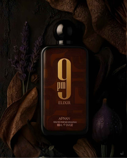 Afnan 9PM ELIXIR EDP perfume bottle surrounded by aesthetic fragrance notes including lavender sprigs, dark wood, and a fresh fig on a textured background.