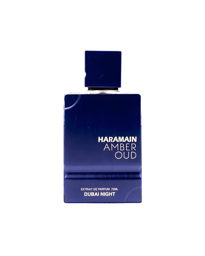 A rectangular, dark blue (or indigo) perfume bottle with a matching square cap. The white text on the front reads AL HARAMAIN AMBER OUD DUBAI NIGHT ExDP and below that "EXTRAIT DE PARFUM 75ML DUBAI NIGHT