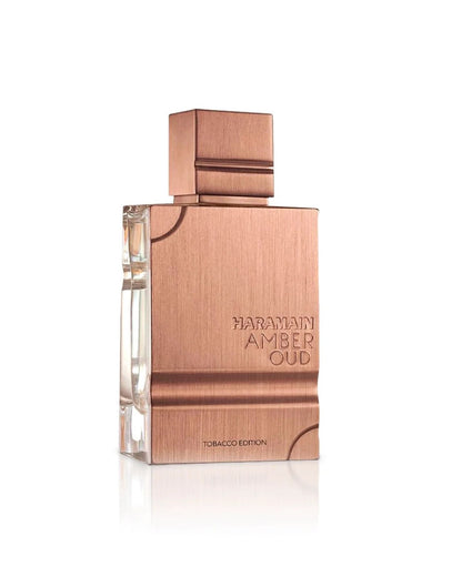 A bottle of Al Haramain Amber Oud Tobacco Edition perfume featuring a brushed copper-tone metallic finish and rectangular cap against a white background.