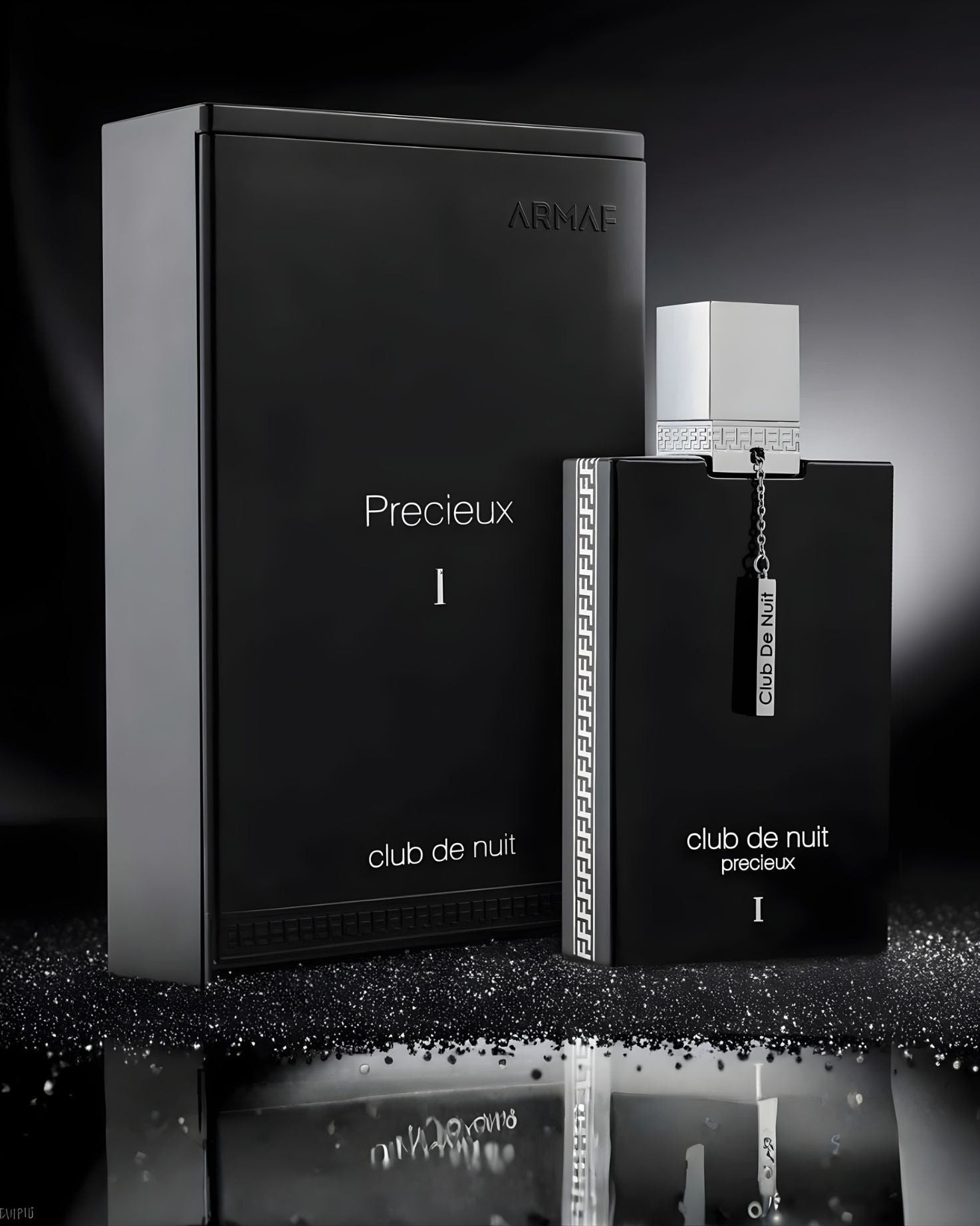 A high-contrast, black and silver still life product shot of the Armaf Club De Nuit Precieux 1 EXdp perfume bottle and its luxury rectangular box on a reflective surface with sparkling glitter.