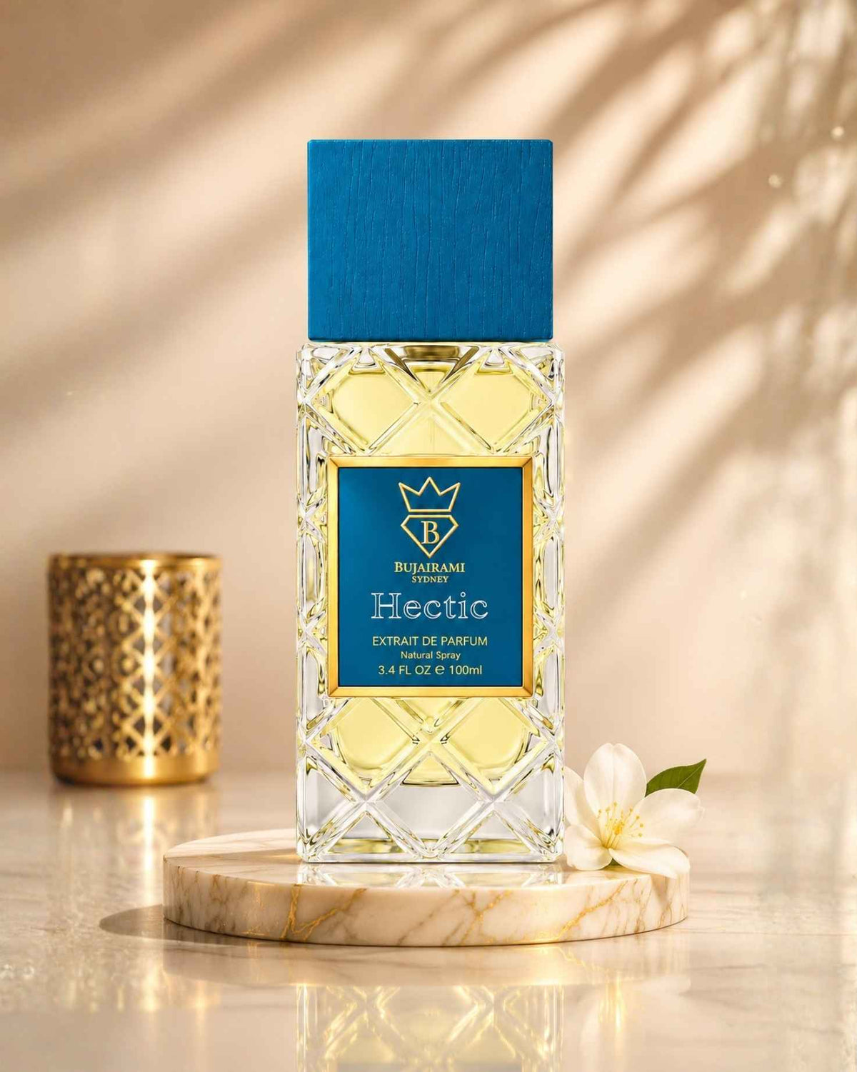Bujairami Sydney Hectic Extrait de Parfum bottle on a round marble tray, accompanied by a white jasmine flower and soft sun shadows.