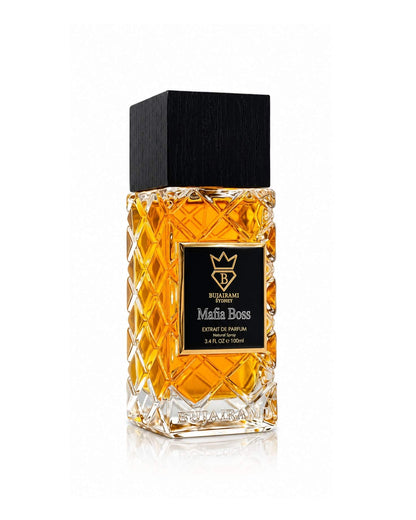Three-quarter side angle view of the Bujairami Sydney Mafia Boss Extrait de Parfum 100ml bottle, highlighting the quilted crystal glass pattern, embossed base branding, black wood cap, and gold-bordered label on a white background.