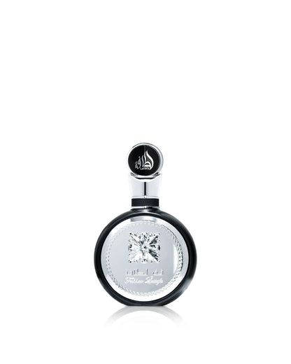 A close-up product shot of the Lattafa "Fakhar Lattafa" perfume bottle, which is round and black with a large, ornate central silver panel and an abstract diamond emblem, isolated against a white background.