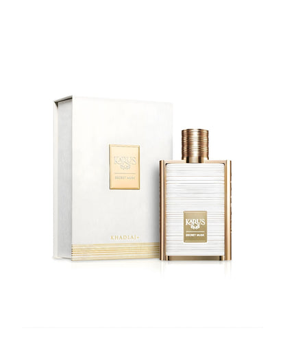 The Khadlaj Karus Secret Musk by Khadlaj Eau de Parfum set, featuring the gold-framed bottle with a textured white center next to its matching white box, which has gold accents and a small gold plaque on the front.