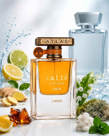 Lattafa Atlas Canyon Eau de Parfum surrounded by fragrance notes of sliced lemon, lime, fresh ginger root, amber resins, and white floral lily of the valley against a water splash background.