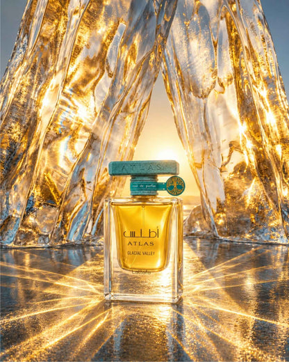 Lattafa Atlas Glacial Valley Eau de Parfum bottle framed by glowing golden ice formations with sunlight streaming through the backdrop.