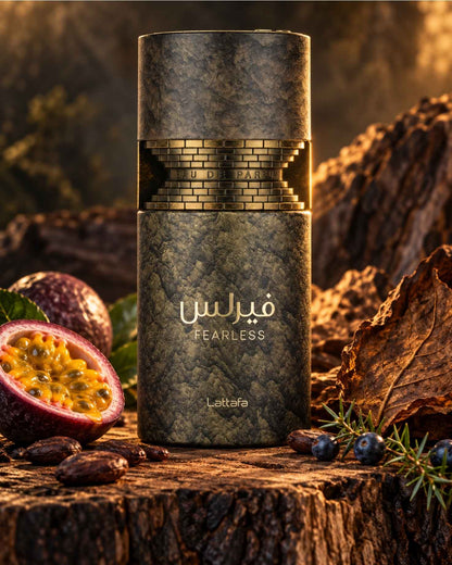 Lattafa Fearless Eau de Parfum textured bottle styled on a wooden surface with a sliced passion fruit, cocoa beans, juniper berries, and dried tobacco leaves.