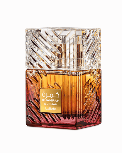Lattafa Khamrah Dukhan Eau de Parfum bottle with crystal-cut textured glass cap and amber-to-crimson gradient liquid body against a plain white background.