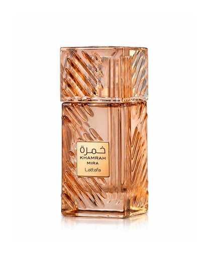 Front view of Lattafa Khamrah Mira Eau de Parfum bottle made of amber-tinted carved crystal glass with a gold logo plate on a white background.