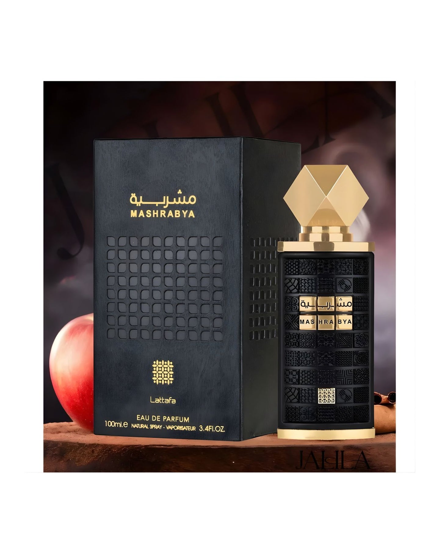 Lattafa Mashrabya Eau de Parfum bottle and its matching black and gold box displayed with a red apple and a cinnamon stick, suggesting a warm, spicy oriental fragrance.