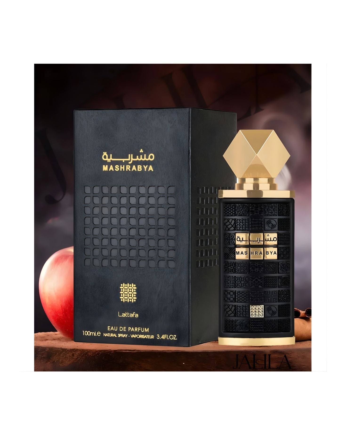 Lattafa Mashrabya Eau de Parfum bottle and its matching black and gold box displayed with a red apple and a cinnamon stick, suggesting a warm, spicy oriental fragrance.