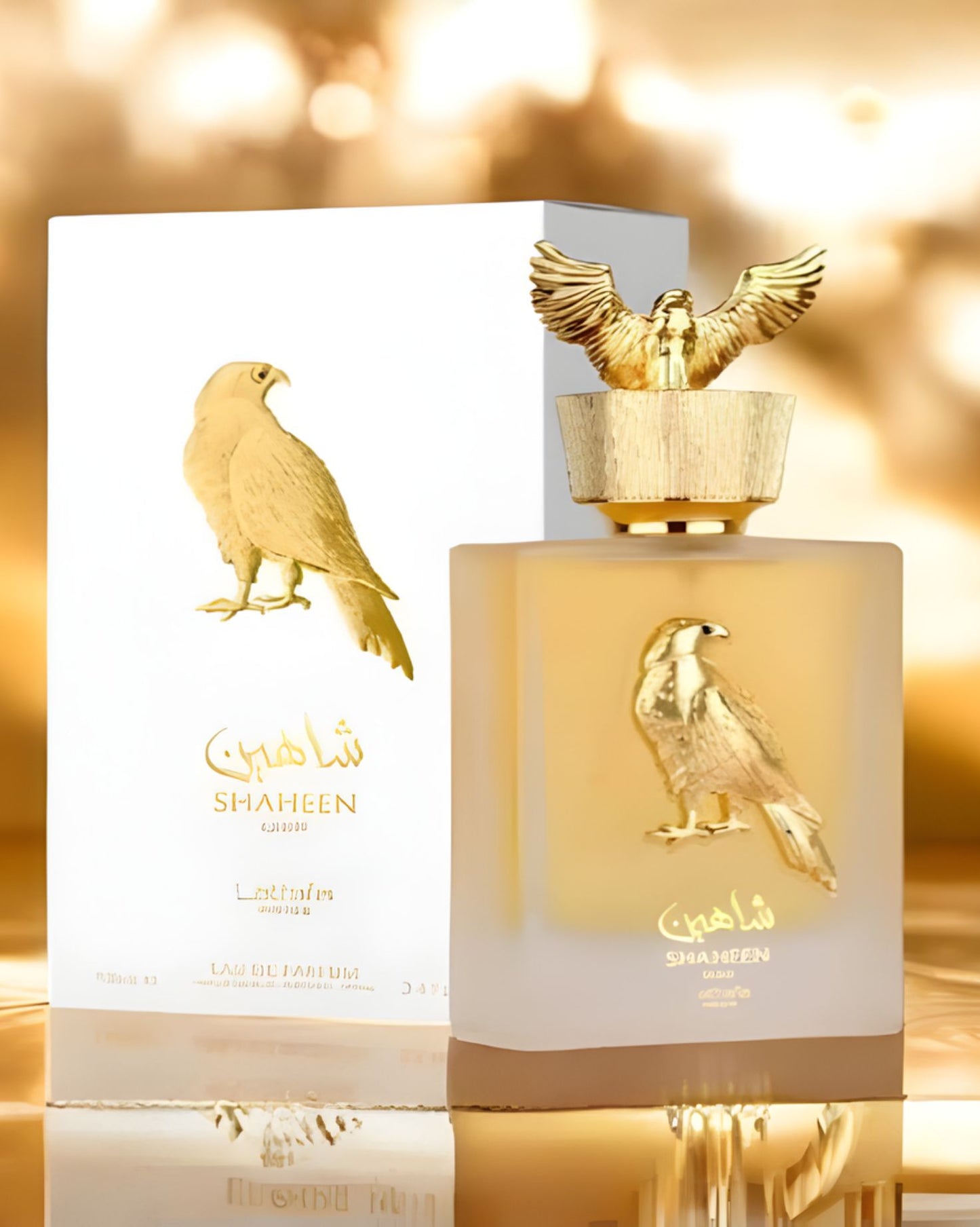 Front view of the Lattafa Shaheen Gold edp perfume bottle and its elegant white and gold retail box, set against a shimmering gold bokeh background.