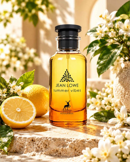 Maison Alhambra Jean Lowe Summer Vibes Eau de Parfum bottle displayed on stone surrounded by fresh lemon slices and blooming white orange blossoms.