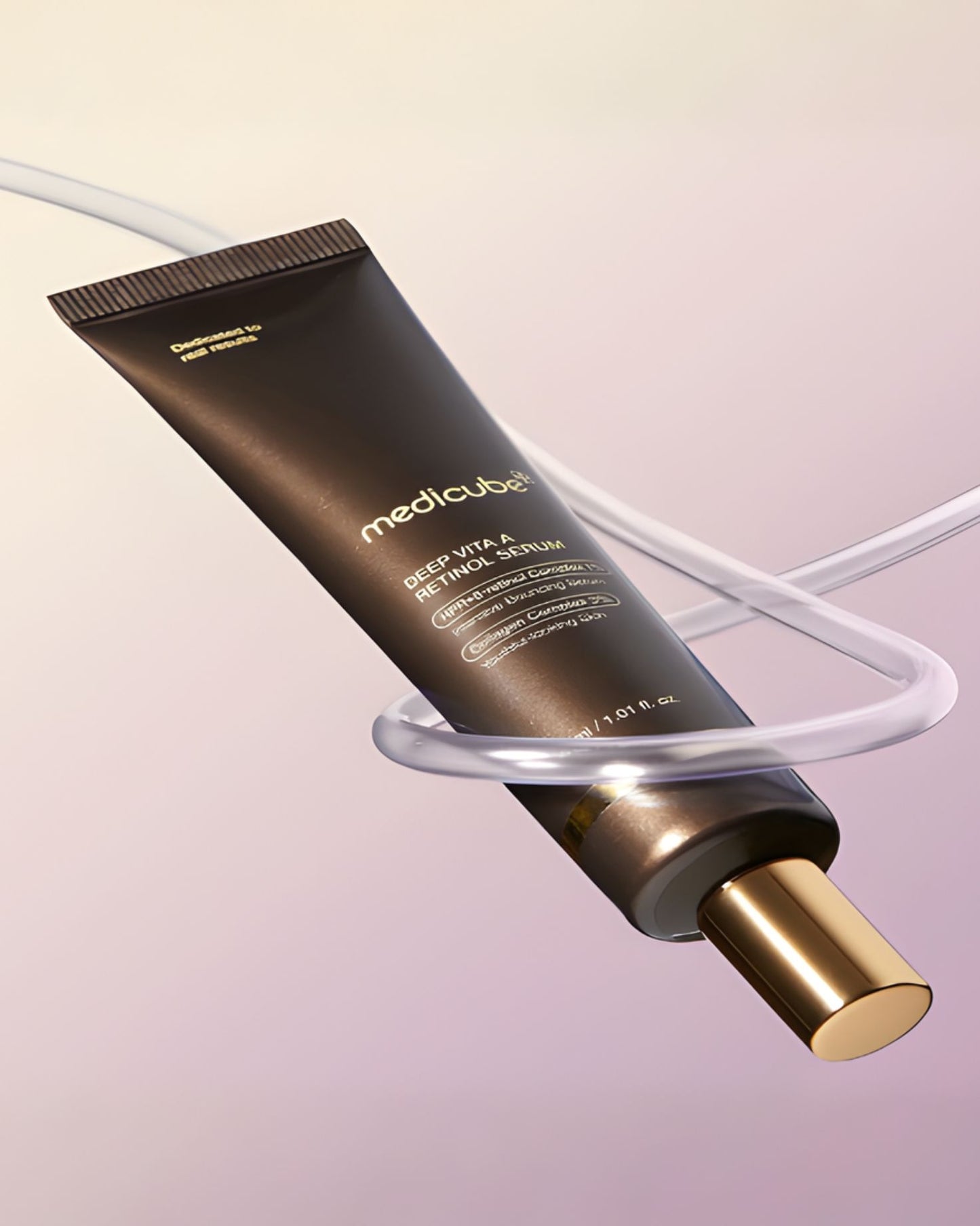A close-up, dynamically angled lifestyle shot of the Medicube Deep Vita A Retinol Serum tube, featuring a glossy brown body and gold cap. The tube is suspended by or wrapped around clear, curved tubing against a soft, gradient background of pink and purple tones. The product name, "DEEP VITA A RETINOL SERUM," and key ingredients like "HPR + 5-retinol Complex 1%" and "Collagen Complex 3%" are visible on the label.