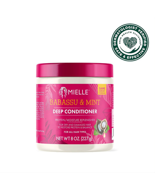 A white jar of Mielle Babassu & Mint Deep Conditioner, a protein/moisture replenisher for dry and damaged hair. The jar has a bright pink label and a pink lid. In the upper right corner, there is a 'Dermatologist Verified Skin Health Alliance Safe & Effective' seal.