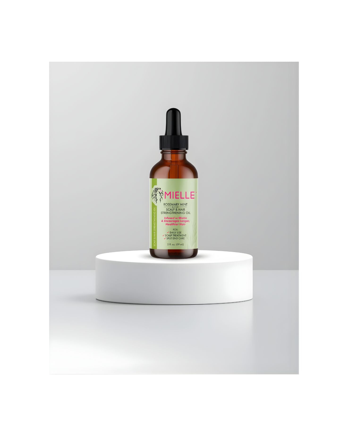 Mielle Rosemary Mint Scalp and Hair Strengthening Oil dropper bottle displayed on a white product stand.