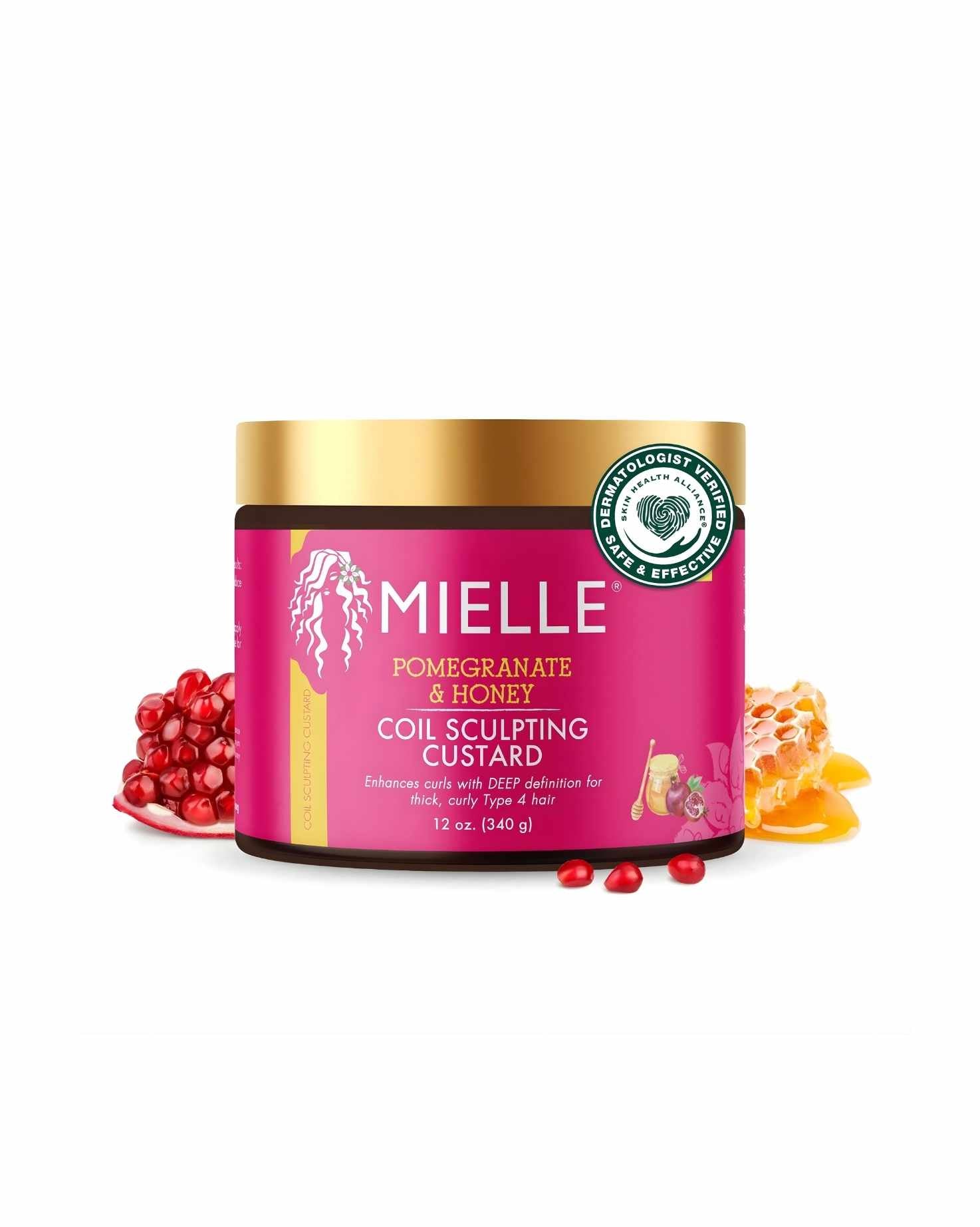 The Mielle Pomegranate & Honey Coil Sculpting Custard jar, featuring a gold lid and a bright pink label. The text indicates it 'Enhances curls with DEEP definition for thick, curly Type 4 hair.' The jar is flanked by cut pomegranates and a piece of dripping honey comb, isolated against a white background.