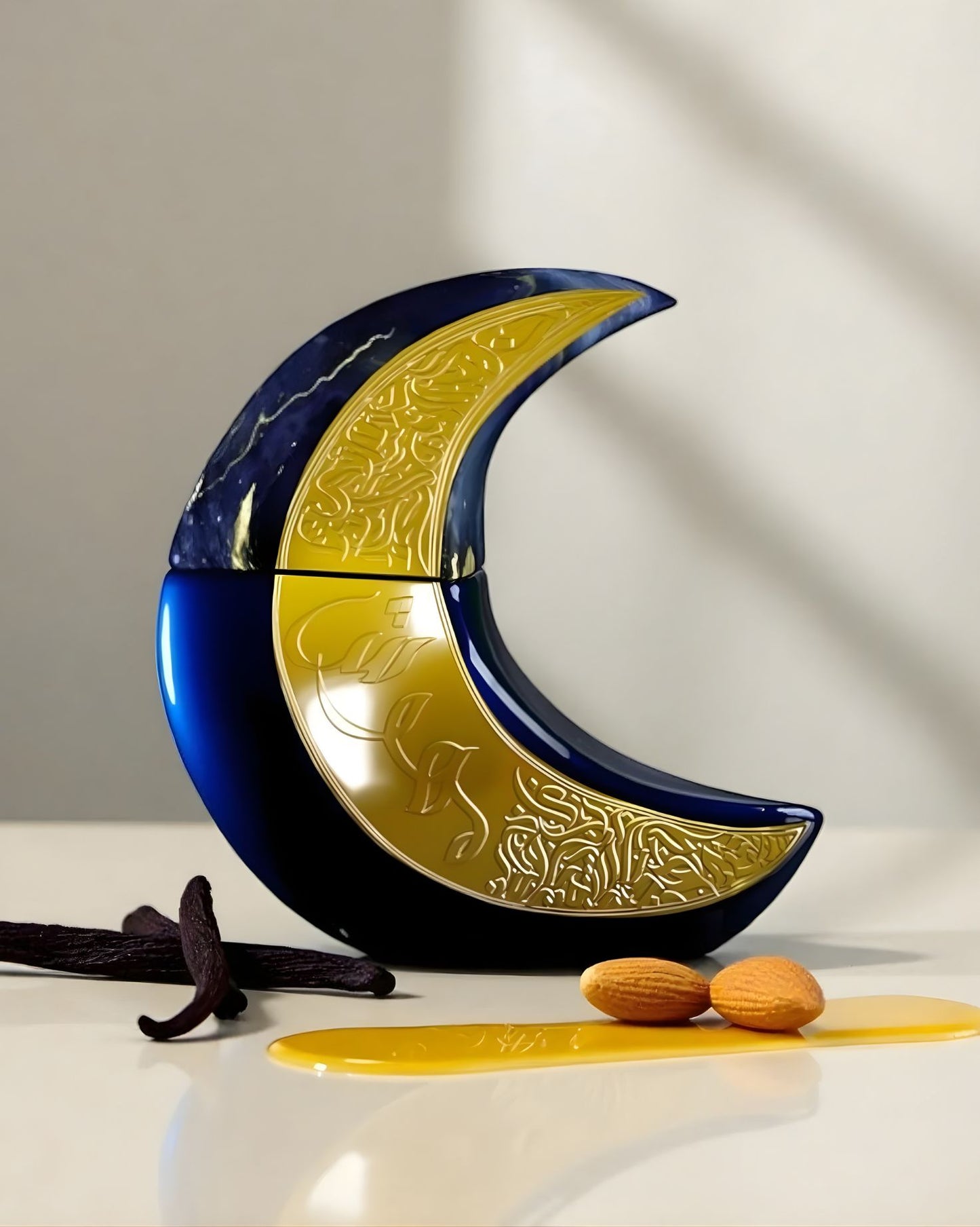A promotional still life shot of the crescent moon-shaped paris corner mehwise edp perfume bottle, which is dark blue and features a gold embossed panel. It is displayed on a glossy white surface next to flavor notes: several dark vanilla beans, two almonds, and a pool of golden liquid, likely honey or vanilla extract.