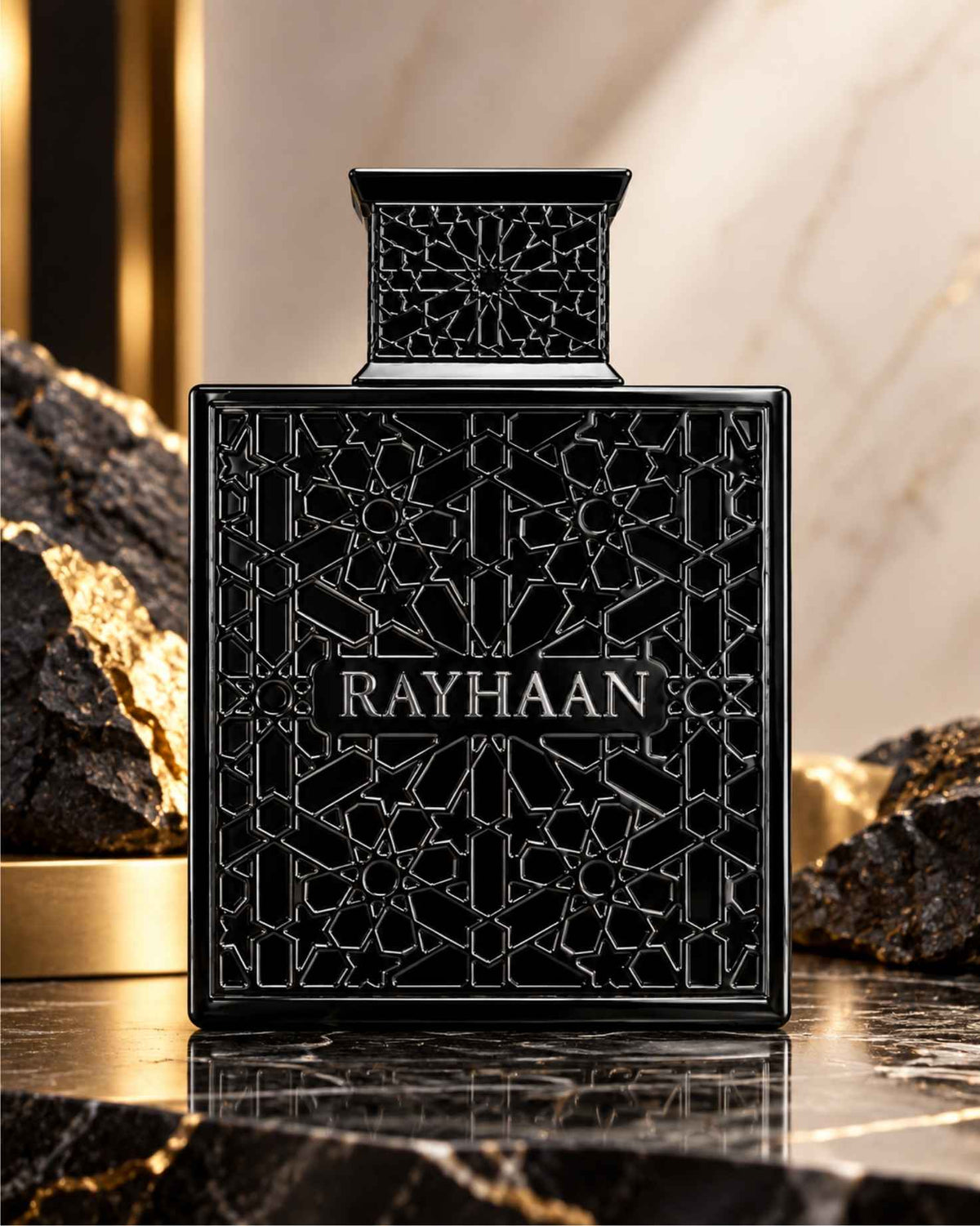 Rayhaan Obsidian Eau de Parfum black geometric latticed bottle displayed on polished dark marble beside black volcanic stones with gold accents.