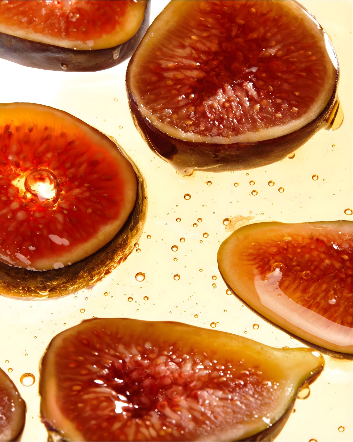 Close up of fresh sliced figs in golden oil, highlighting the natural fig extract ingredient in Shea Moisture Manuka Honey and Mafura Oil shampoo.