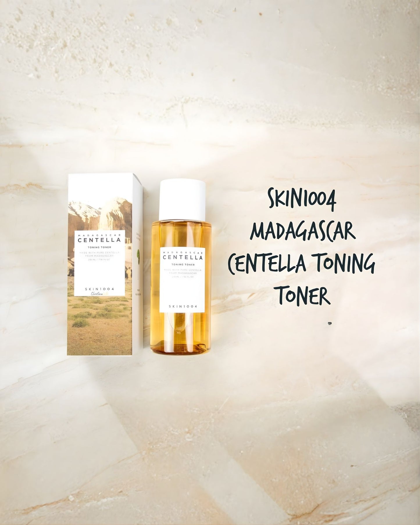SKIN 1004 Madagascar Centella Toning Toner in an amber-colored bottle and its box, displayed on a light marble surface. Handwritten text labels the product in the image