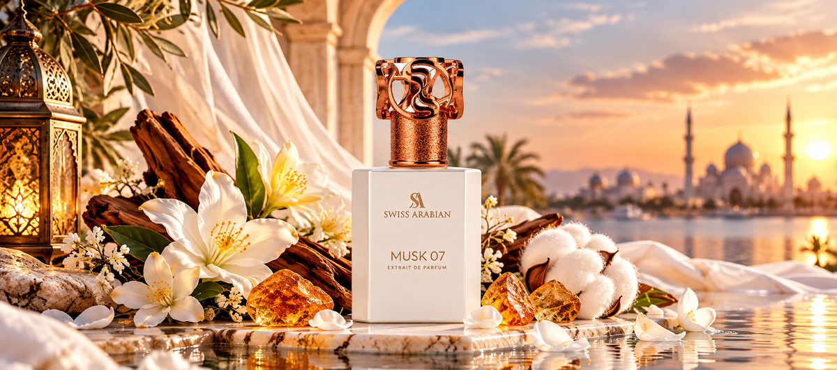 Swiss Arabian Musk 07 Extrait de Parfum white bottle with a gold cap displayed on marble beside amber resin, cotton blooms, and white flowers with a sunset mosque background.