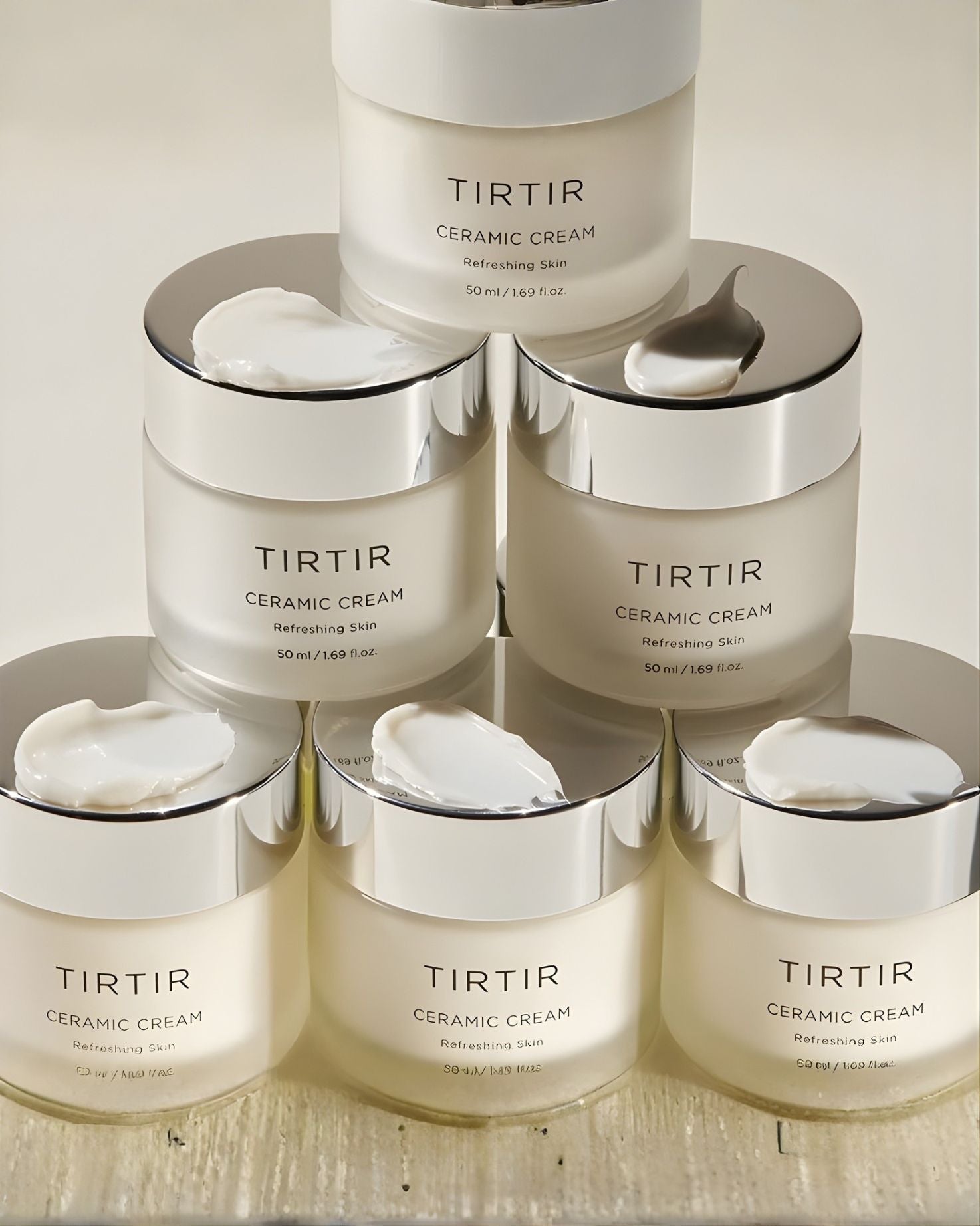 Simple, clean product shot of the TIRTIR Ceramic Cream jar (50 ml), labeled "Refreshing Skin," with a frosted white glass container and silver metallic cap.