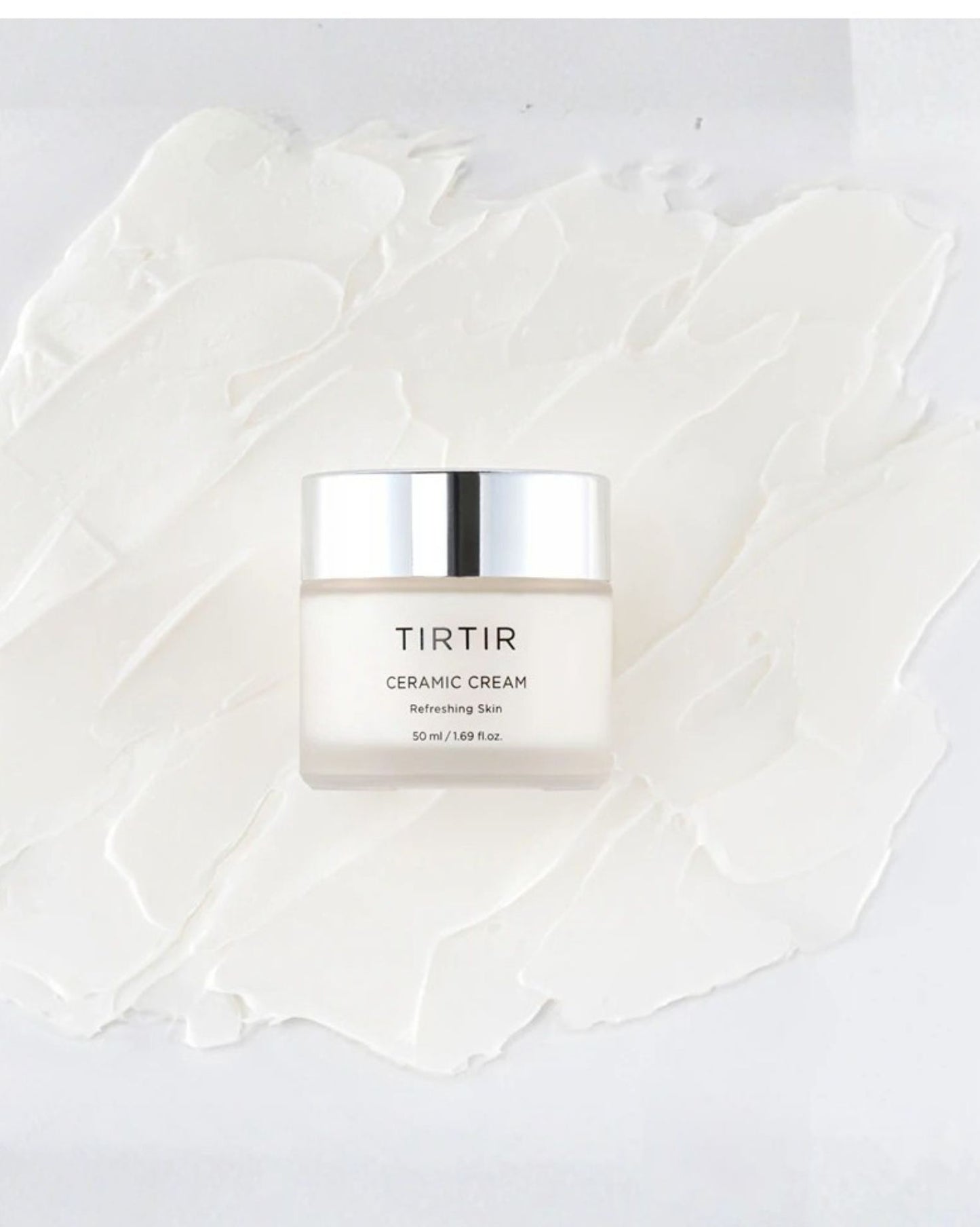 The TIRTIR Ceramic Cream jar, 50 ml, resting on a thick, textured white swatch of cream, labeled 'Refreshing Skin' with a silver cap.