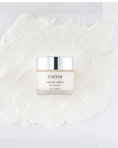 The TIRTIR Ceramic Cream jar, 50 ml, resting on a thick, textured white swatch of cream, labeled 'Refreshing Skin' with a silver cap.