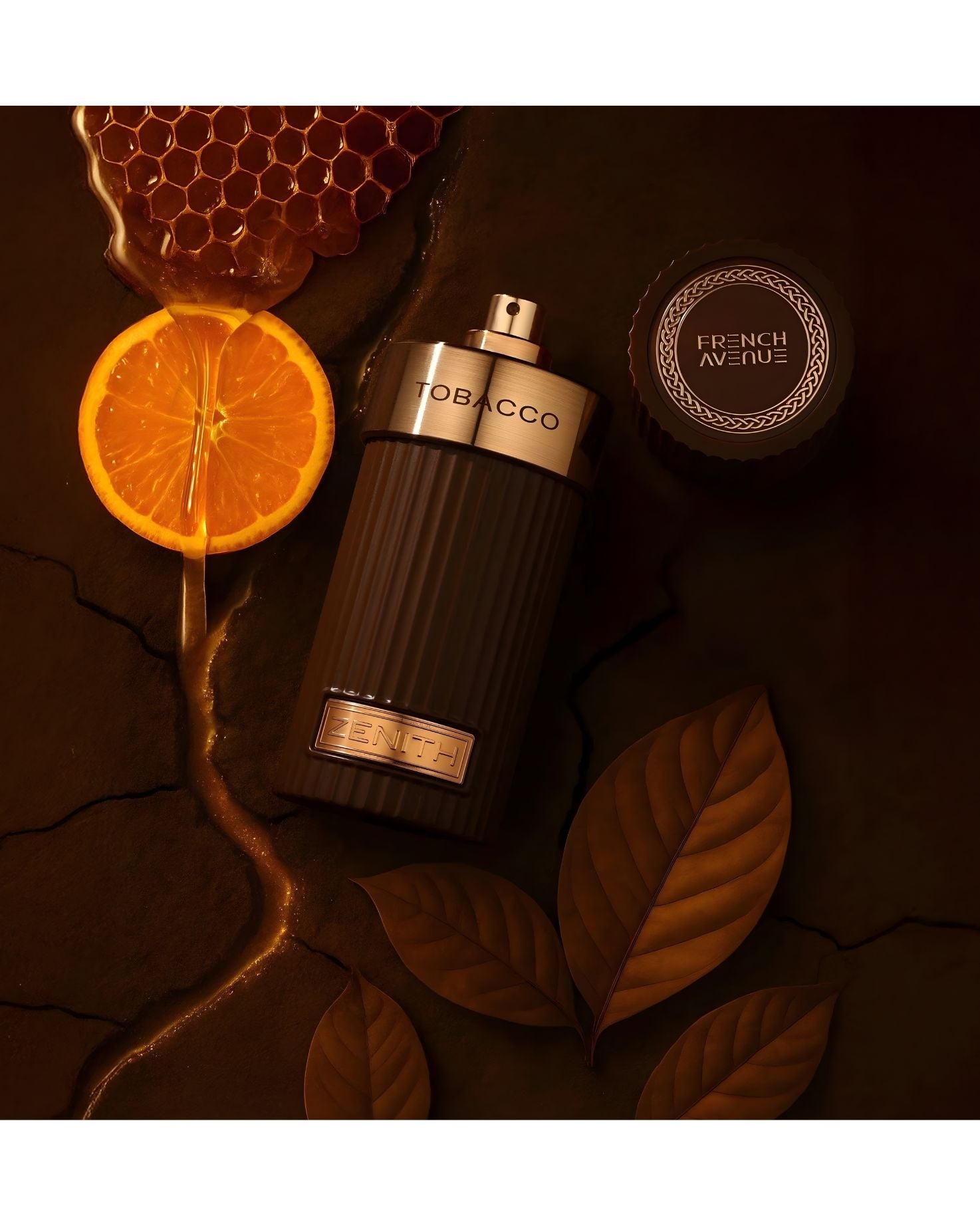 A stylish bottle of Tobacco Zenith by French Avenue placed on a warm brown surface with honeycomb, an orange slice, and tobacco leaves, creating a rich and cozy vibe.
